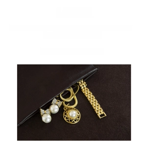 Close-up of vintage gold jewelry set with pearls displayed in a luxury leather gift pouch