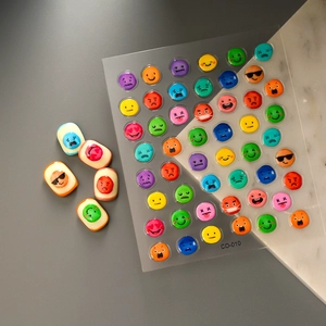 Macro shot of 3D colorful emoji nail art stickers with various facial expressions