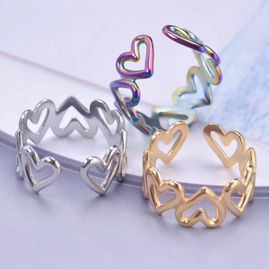 Three open heart-shaped stainless steel rings in gold, silver and iridescent finishes