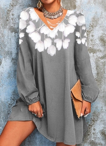 Detail of the V-neckline and white floral print on a grey long-sleeved mini dress