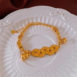 Detail of gold gourd and ancient coins on a retro Chinese style beaded bracelet charm