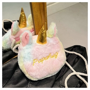 Detail of plush rainbow unicorn crossbody bag with gold horn and soft fur texture