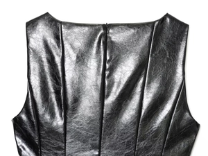 Dettaglio del top in similpelle lucida con trama del tessuto e zip posteriore