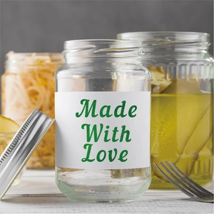 Close-up of clear glass jar with Made With Love sticker label and stainless steel lid