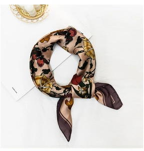 Detailed macro view of vintage floral and butterfly pattern on silk-like square scarf
