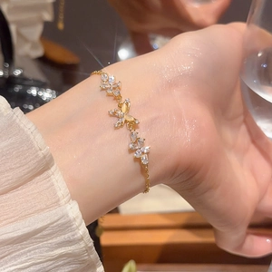 Detail of 18k gold plated bracelet with zircon butterflies and cat-eye stone accents