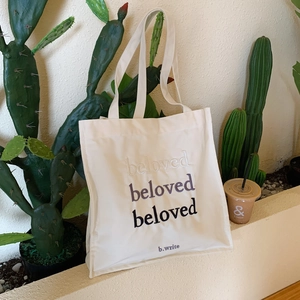 Détail de la broderie beloved sur le sac cabas minimaliste en toile beige pour femme