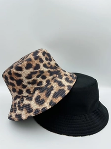 Detail view of leopard print and solid black reversible bucket hats in durable cotton canvas