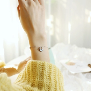 Waterproof stainless steel chain bracelet with heart shell pendant on a female wrist