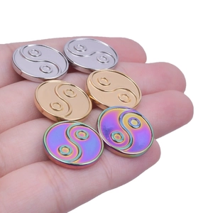 Macro detail of yin yang earrings in silver gold and rainbow finishes on stainless steel