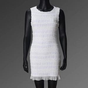 Détail de la robe mini blanche sans manches avec un tissu élastique à texture froncée