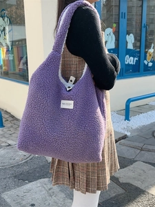 Purple fleece reversible tote bag with a white label for winter fashion students