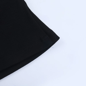 Detailed macro view of black ribbed knit fabric and precise double-stitched hem finish