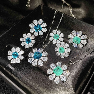Detailed view of flower-shaped jewelry sets with blue and green gemstones in a gift box