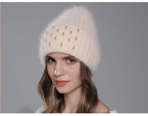 Close-up of cream knit beanie with soft rabbit fur texture and sparkling rhinestone details