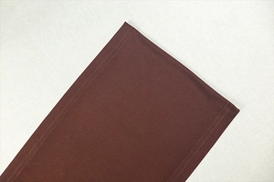 Detail of double-stitched hem on high-neck brown knit dress with fine texture