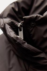 Detailed macro shot of the stand-up collar with matching resin zipper and metal snaps