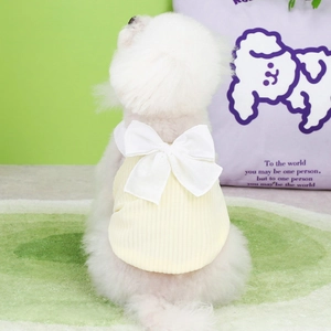 Close-up of yellow knit pet dress with large white bow on a Pomeranian puppy back