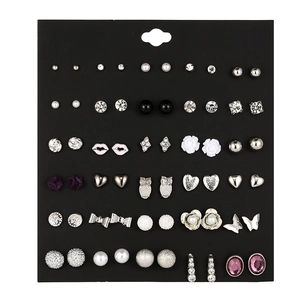Close-up of 30 pairs of assorted stud earrings with pearls and crystals on black card