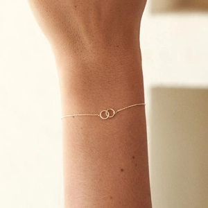 Detailed view of a minimalist S925 sterling silver interlocking double ring bracelet in gold