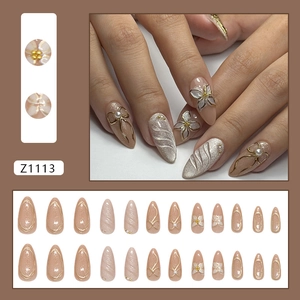 French almond press-on nails with 3D gold-edged flowers, pearls, and cat eye shimmer