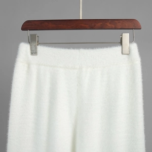 Close-up of white plush knit trousers with elastic waistband and fuzzy mohair texture