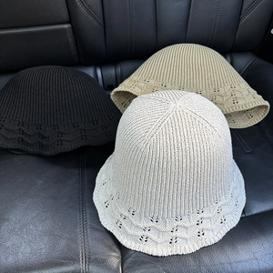Detail of knitted bucket hats in black, khaki, and beige with wavy hollow patterns