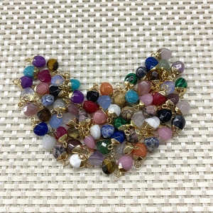 Detailed close-up of faceted tiger eye oval pendants in assorted vibrant colors with gold clasps