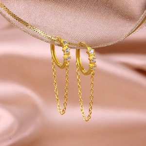 Detail of gold star tassel earrings with rhinestones hanging on champagne silk ribbon