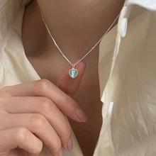 Dettaglio del ciondolo a cuore in opale blu su una catena a sfere in argento lucido