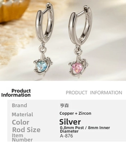 Detail of silver heart earrings with blue and pink zircons on beige velvet background