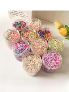 Detailed view of ten jars of colorful elastic hair bands for girls in pastel macaroon tones