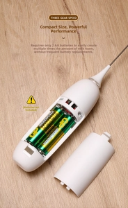 Detail view of the battery compartment in a white handheld electric milk frother