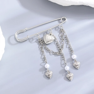 Detailed view of silver safety pin brooch with hanging heart charms and pearls
