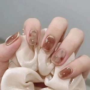 Brown cat eye press-on nails with floral ink painting and elegant gold trim edges