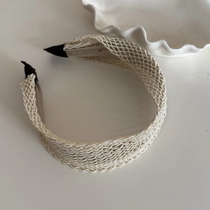 Detail of cream woven wide headband showing textured fiber knit and black protective ends