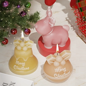 Detailed view of Christmas elk and bell scented candles with Merry Christmas relief