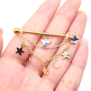 Piercing industriale dorato con stelle pendenti, lune e perline con effetto cangiante