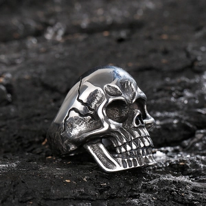 Macro shot of punk style skull ring with vintage silver finish on dark texture