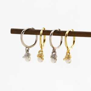 Detailed view of gold and silver S925 snake earrings with dangling pearl pendants