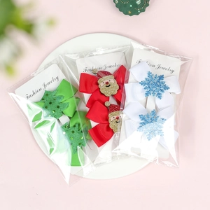 Detail of Christmas ribbon bow hair clips with glittery Santa and tree accents