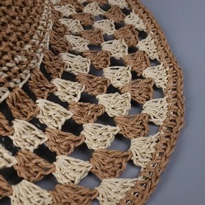 Detailed close-up of brown and beige checkerboard hand-woven straw hat texture