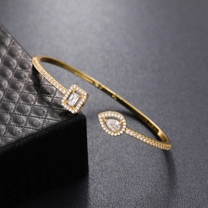 Minimalist gold open bangle with sparkling cubic zirconia in rectangle and teardrop shapes