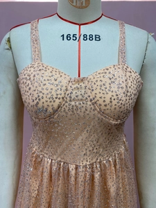Détail d'une robe en tulle rose avec des paillettes argentées sur un mannequin