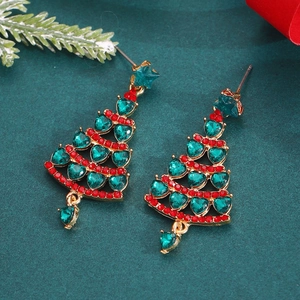 Detailed macro of gold Christmas tree earrings with emerald heart and red round crystals