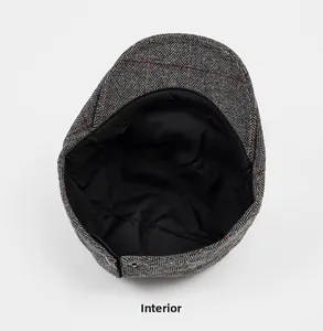 Macro view of the internal lining and stitching of a grey tweed newsboy cap