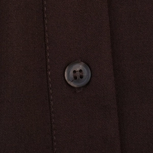 Detail view of dark brown fabric texture with resin buttons and reinforced stitching