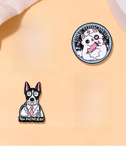 Macro detail of cartoon nurse cat and doctor dog enamel pins on a warm fabric background
