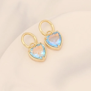 Close-up of gold 18K plated earrings with light blue gradient crystal hearts