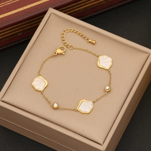 Golden bracelet with white shell flower elements and sparkling diamonds in a jewelry box